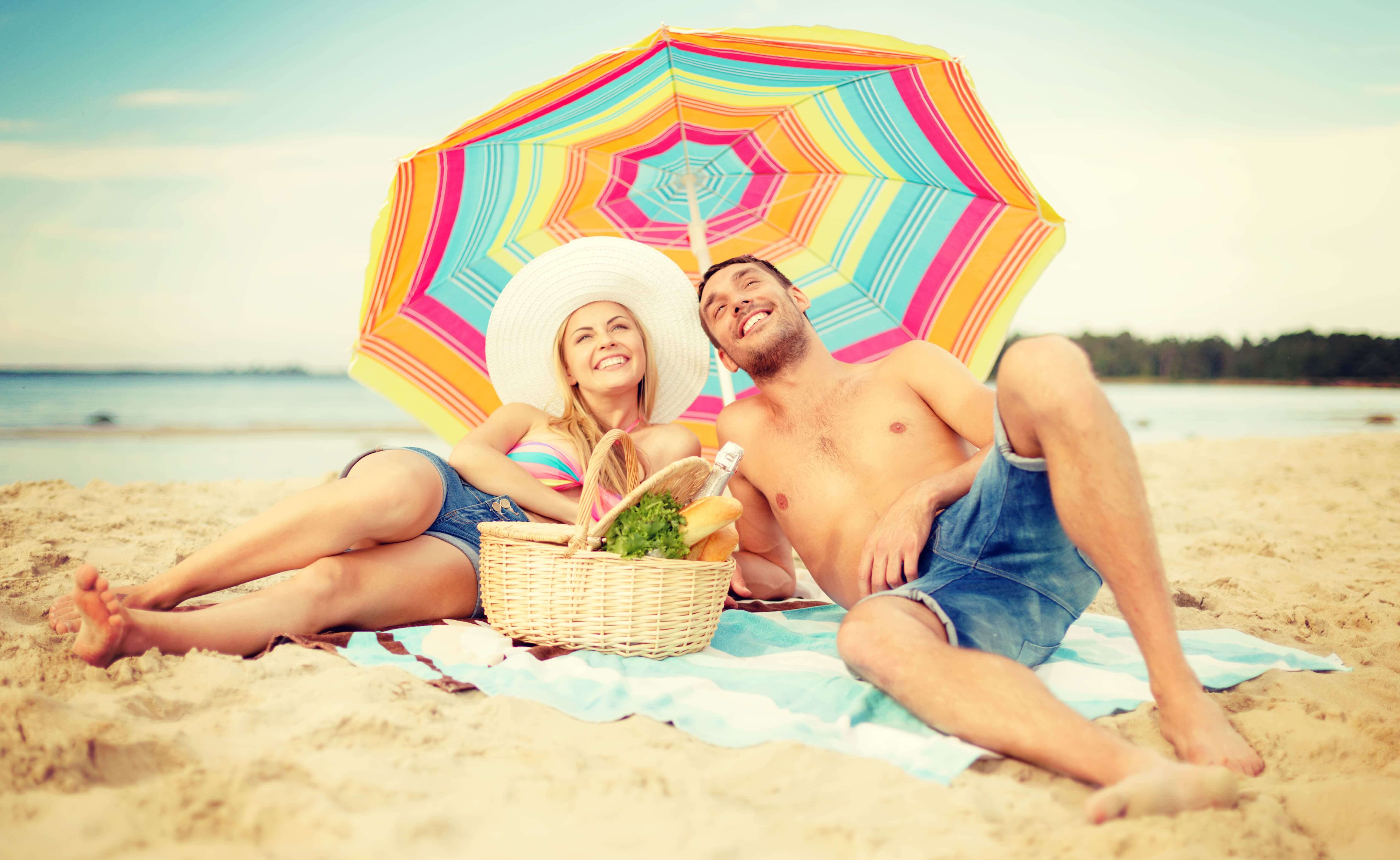smiling couple sunbathing on the beach