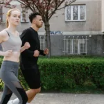 Man en vrouw joggen samen op een parkpad in het voorjaar, matige cardio die de afweer prikkelt