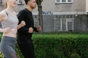 Man en vrouw joggen samen op een parkpad in het voorjaar, matige cardio die de afweer prikkelt