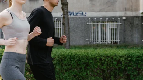 Man en vrouw joggen samen op een parkpad in het voorjaar, matige cardio die de afweer prikkelt