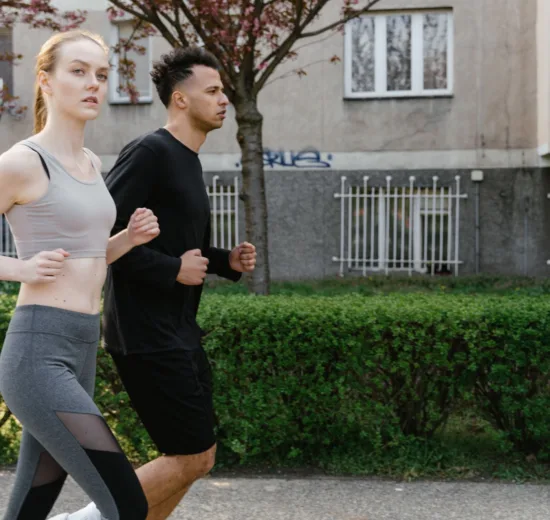 Man en vrouw joggen samen op een parkpad in het voorjaar, matige cardio die de afweer prikkelt