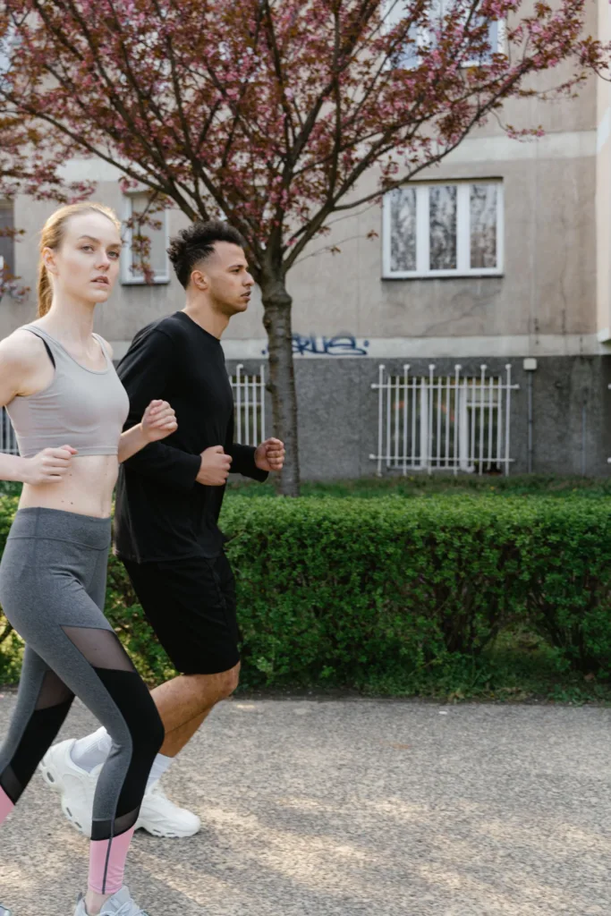 Man en vrouw joggen samen op een parkpad in het voorjaar, matige cardio die de afweer prikkelt